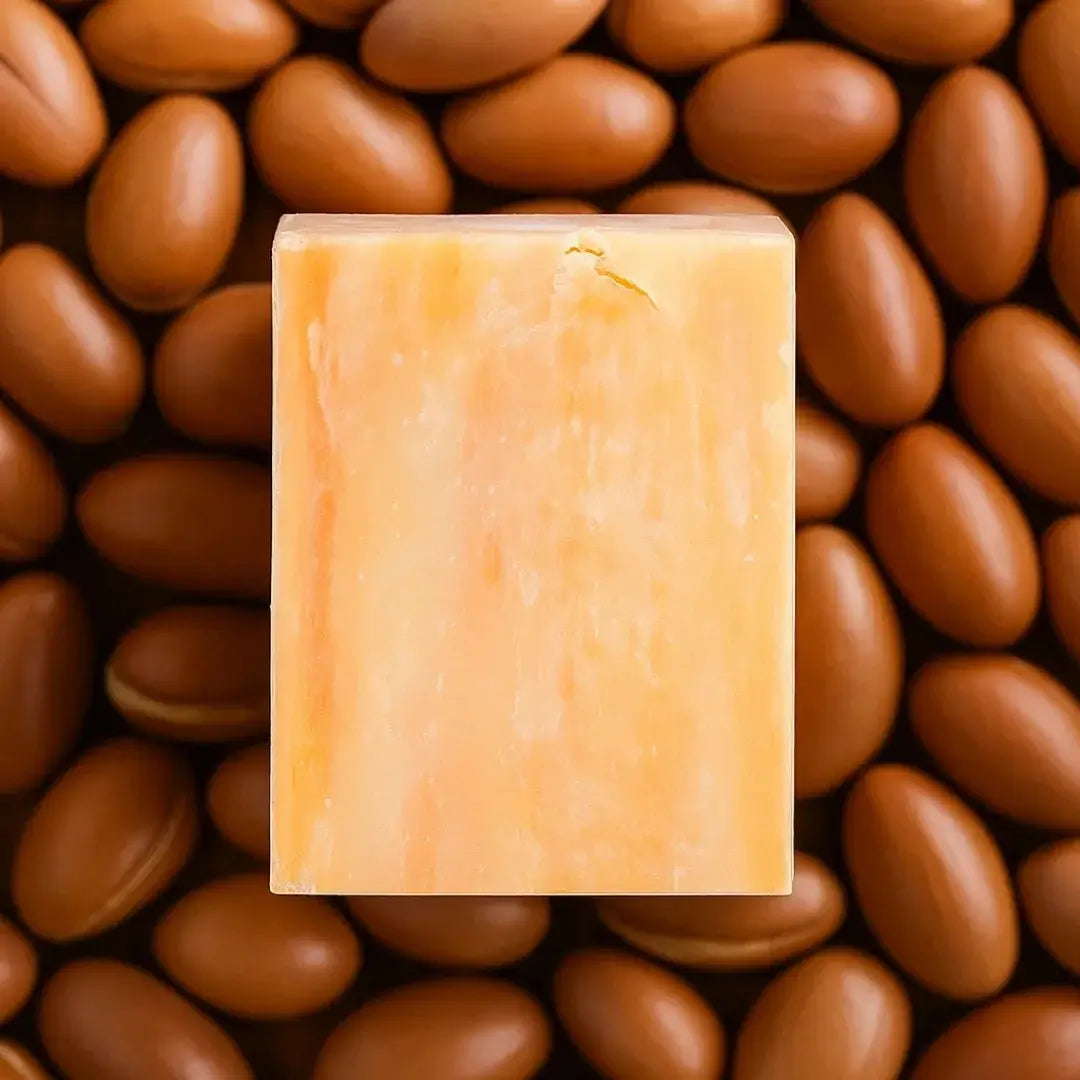 Miara Essence Argan Oil Natural Soap placed on argan nuts, emphasizing its nourishing properties for glowing skin.