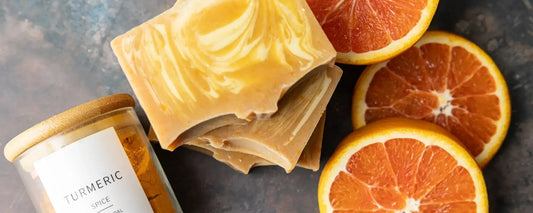 Turmeric Soap with fresh orange slices and a spice jar, highlighting natural skincare benefits for acne.