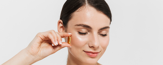 Woman holding a supplement capsule, symbolizing science backed supplements to slow aging and anti-aging support with natural herbs and vitamins.