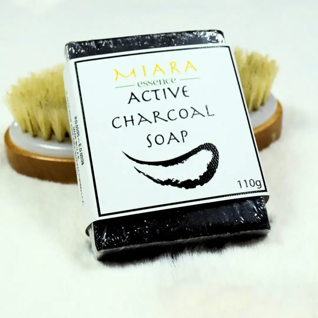 Bar of active charcoal soap activated charcoal soap with packaging and a brush in the background