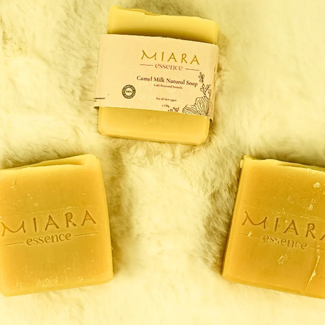 Three bars of MIARA essence camel milk natural soap on a soft, light-colored surface.